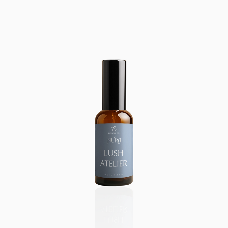 50ml Lush Atelier fragrance mist in amber glass bottle with black cap and muted slate blue label, photographed on white background