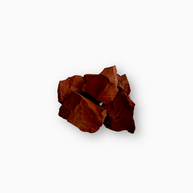 Cluster of raw Red Jasper stones in deep brick red tones, showcasing angular cuts and a matte, unpolished surface, set against a white background.