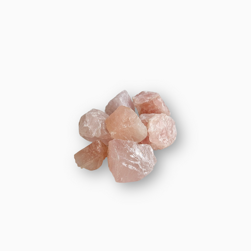 Cluster of raw Rose Quartz crystals with soft pink hues placed on a clean white background.