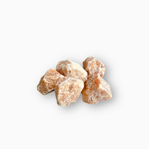 Raw Sunstone crystals with a muted peach-orange hue and subtle shimmer, featuring a chalky surface texture, arranged on a clean white background.