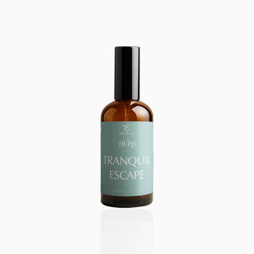 100ml Tranquil Escape fragrance mist in amber glass bottle with black cap and seafoam green label, photographed on white background